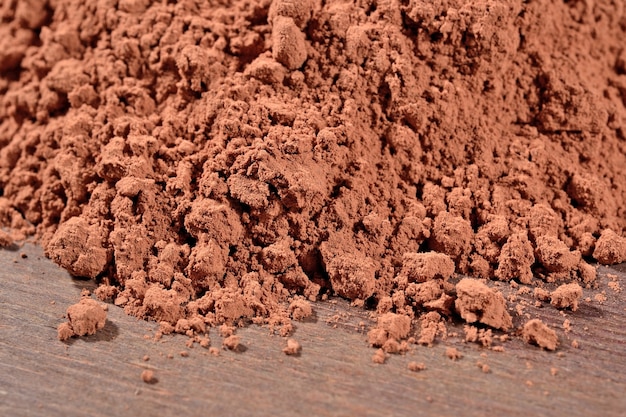 Heap of cocoa powder on a wooden background