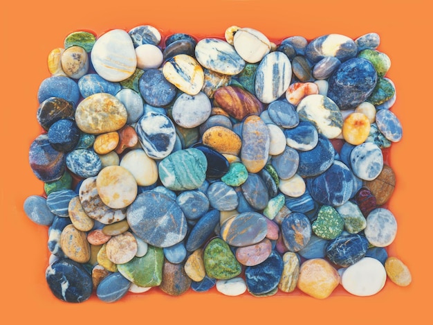 Heap of colorful pebbles on orange background