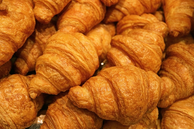 Heap of fresh baked mouthwatering butter croissant pastries, Food texture background