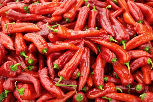 Heap of fresh red chili peppers at a market as a background.