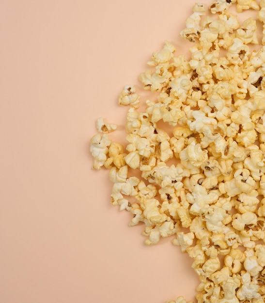 Heap of fried popcorn with cheese on a beige background