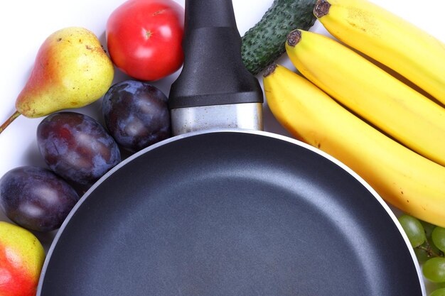 Heap of fruits and vegetables closeup Fresh colorful organic vegetables and fruits with frying pan on white background Copy space