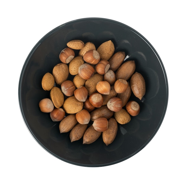 Heap of Macadamia Nuts, Hazelnuts and Almonds in Shell. Nut Mix in Black Bowl Isolated Top View