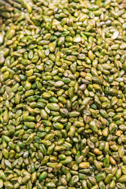 Heap of peeled and fresh green pistachios background.