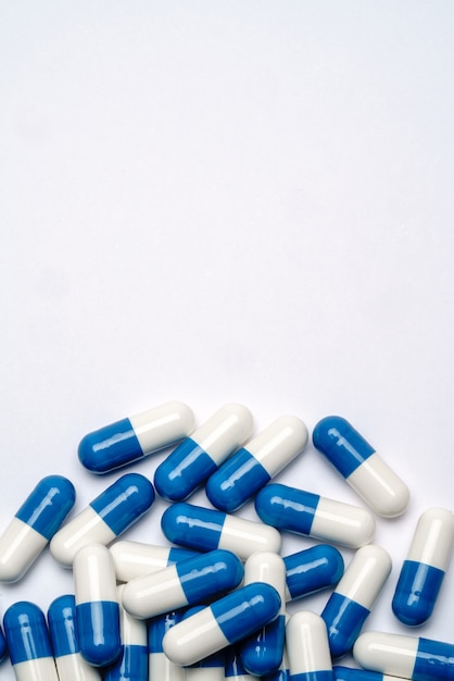 Heap of pills capsules over light grey background