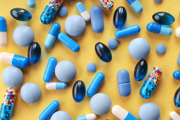 Heap of pills on yellow background