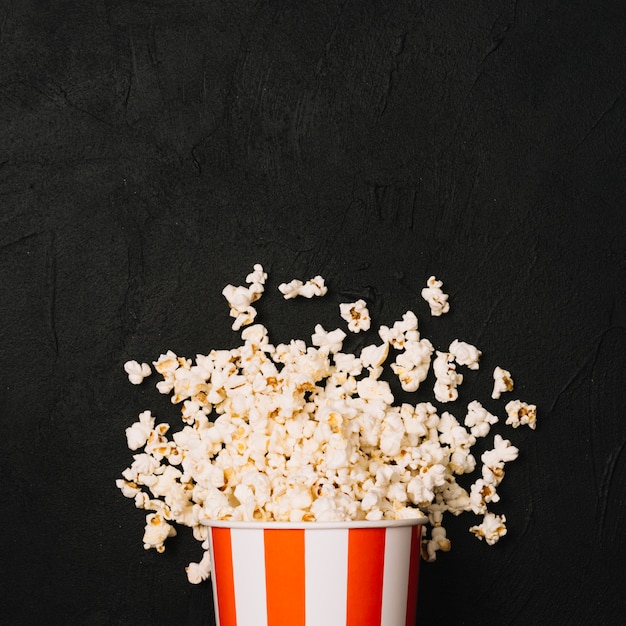 Heap of popcorn spilled from striped bucket