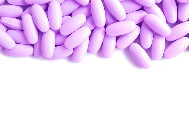 Heap of purple pills on white background with copy space