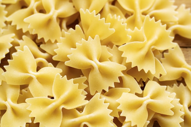 Heap of raw farfalle italian pasta background Ingredient for Mediterranean cuisine