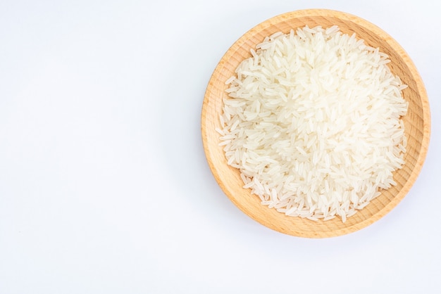 Heap of raw rice on wooden bowl