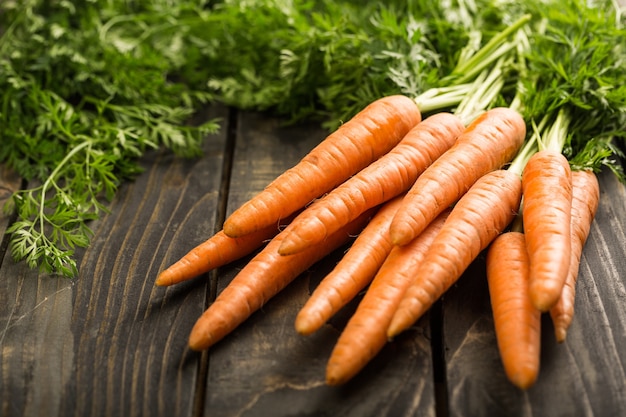 Heap of ripe carrots isolated on wooden table