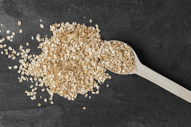 Heap of rolled oats with wooden spoon