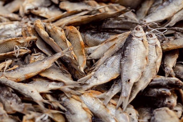 Heap of salted dried fish on string on the market. Traditional Russian food. Selective focus