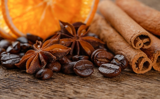 Heap of spices and coffee beans on wooden background. Copy space, close up