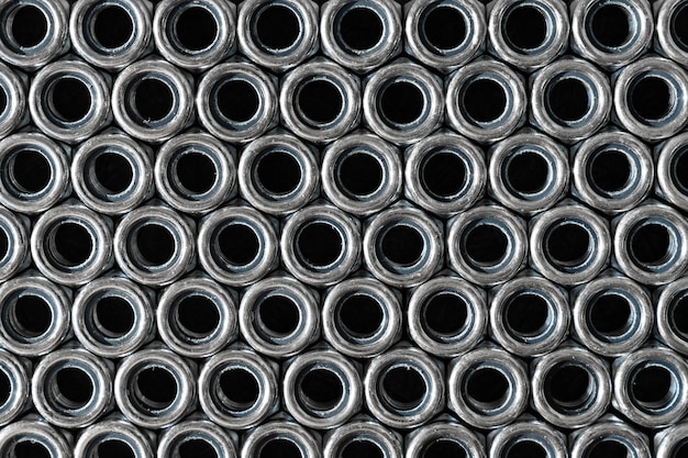 Heap of stainless screw-nuts on wooden background.