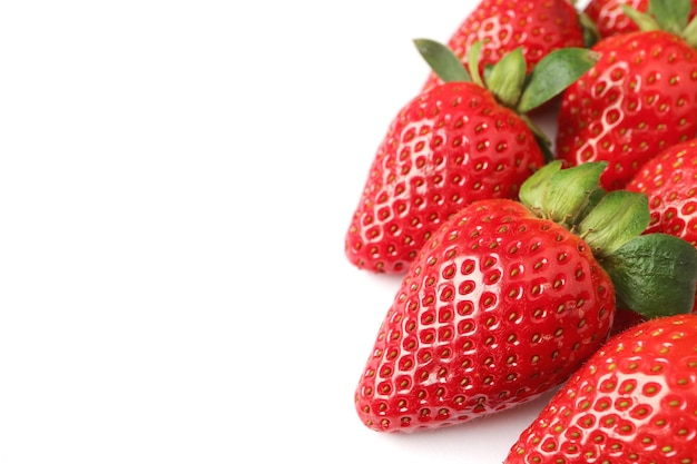 Heap of vibrant red fresh ripe strawberries on white backdrop