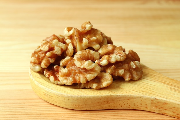 Heap of Walnut Kernels on a Wooden Spoon on Wooden Table