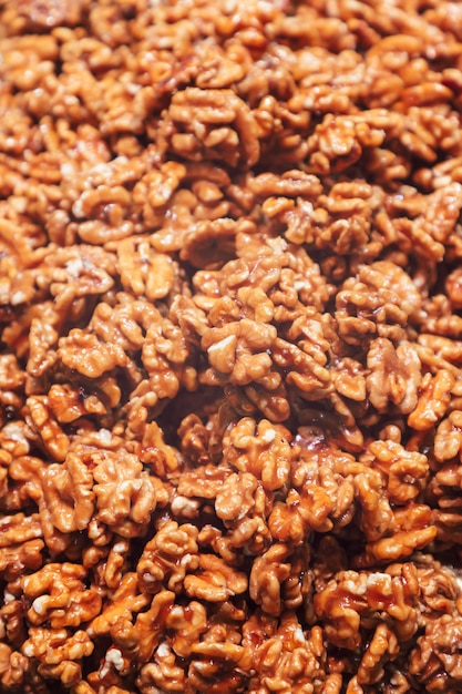 Heap of walnuts in sugar glaze background