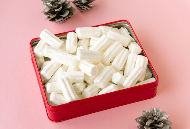 Heap of white marshmallows in box on pink