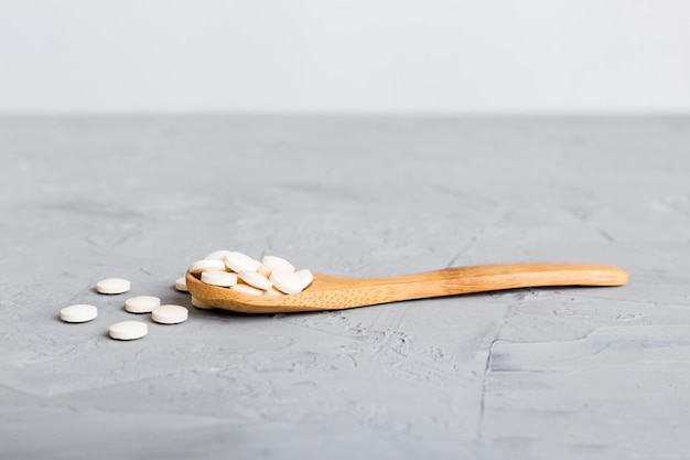 Heap of white pills on colored background Tablets scattered on a table Pile of red soft gelatin capsule Vitamins and dietary supplements concept