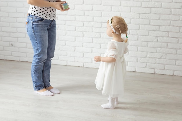 Hearing aid or cochlear implant in baby girl's ear Toddler child wearing a hearing aid at home Deafness concept