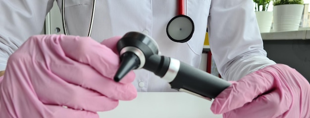 Hearing aid ENT doctor with otoscope closeup