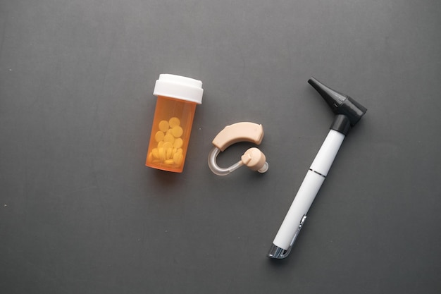 Hearing aid equipment and medical pill container on black