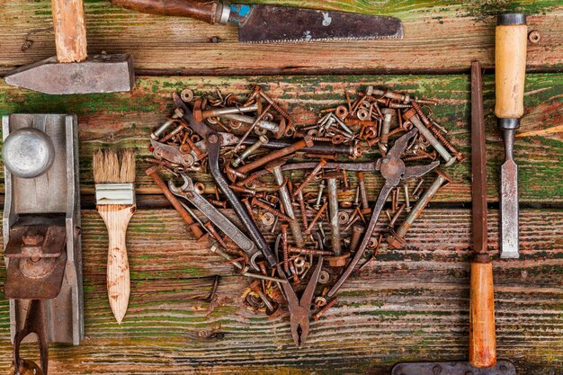 Heart of bolts and nuts on a wooden background