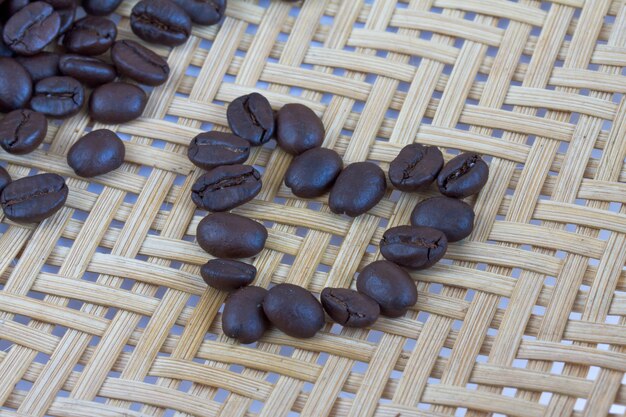 Heart coffee seeds on wood bamboo background 