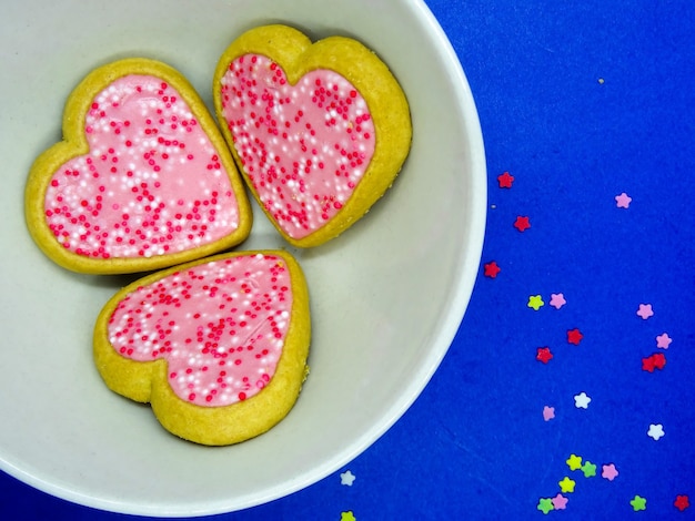 Heart cookies in a plate, blue background with copy space