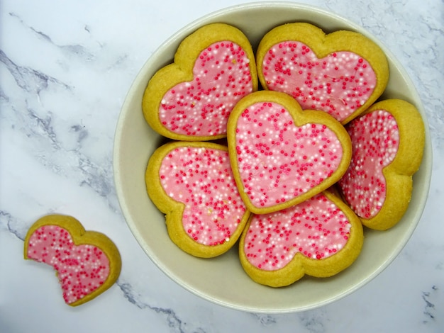 Heart cookies in a plate and one bitten cookie