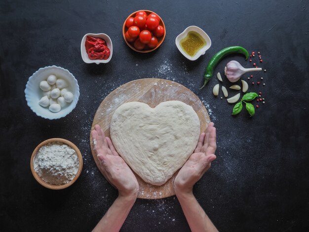 Heart of dough in the hands. Top view.