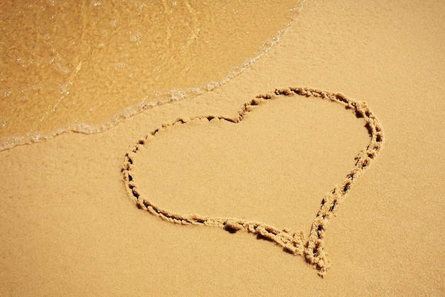 Photo heart drawing in the sand beach.