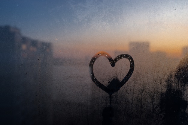 Heart drawn on moisturized glass window