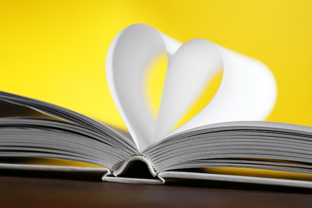 Photo heart from book pages on yellow blurred background