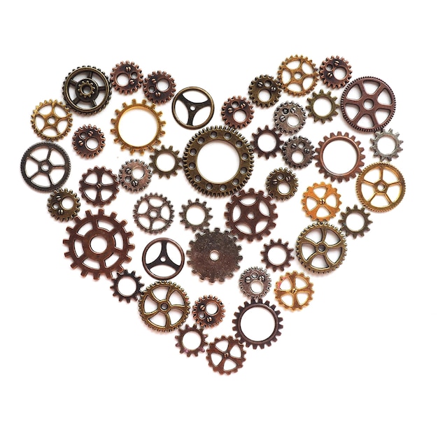 The heart of the gears of bronze, silver, gold and copper shades of different diameters and type on a white background.