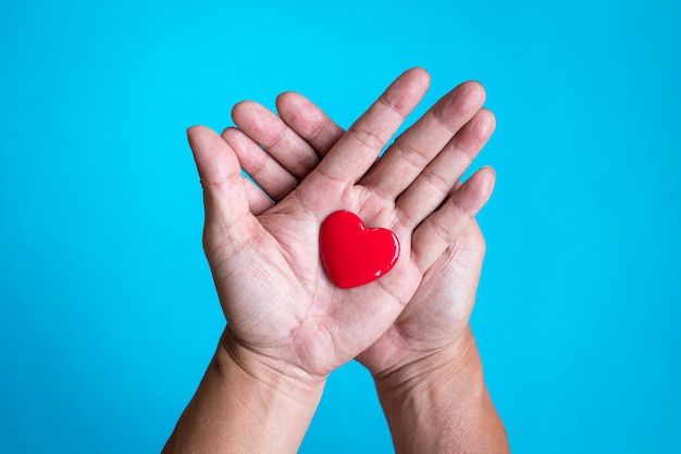 Heart health concept Red heart shape on the palm of hand