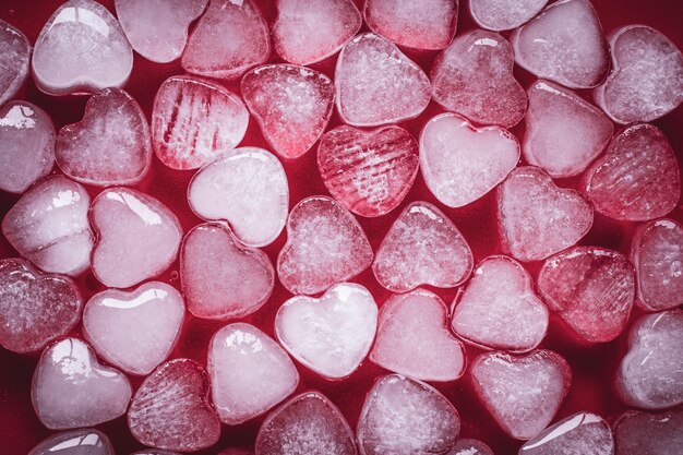 Heart of ice on red background. Romantic card with frozen hearts.