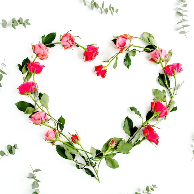 The heart is lined with red roses on white background valentines background floral pattern flat lay