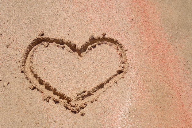 Photo the heart is painted on the colored sand on a tropical beach.