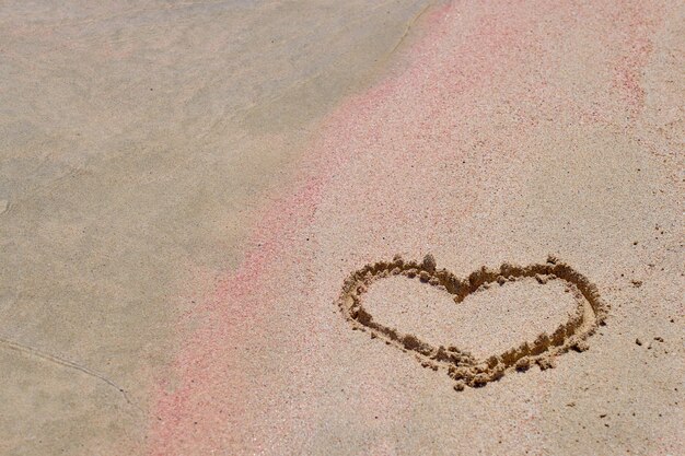 Photo the heart is painted on the colored sand on a tropical beach.