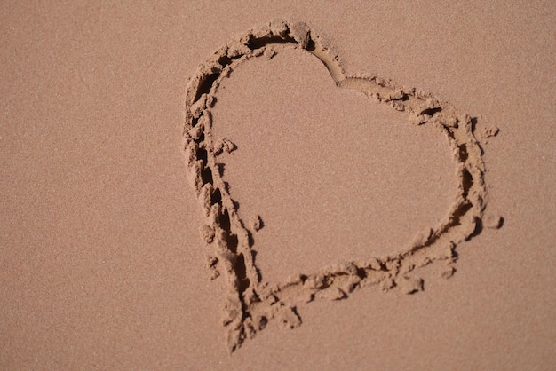 Heart is painted on sand of sea beach closeup