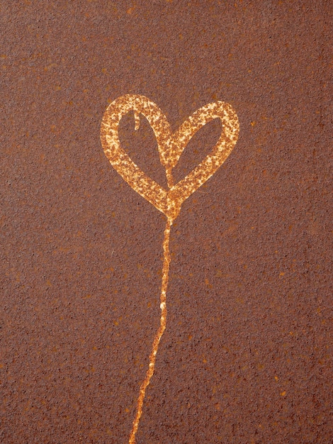 Heart painted on rusty surface. Corrosion of metal texture closeup. Heavily corroded metal sheet.