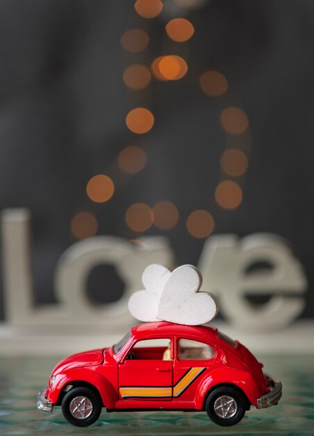 Photo heart on the roof of the tiny toy red car