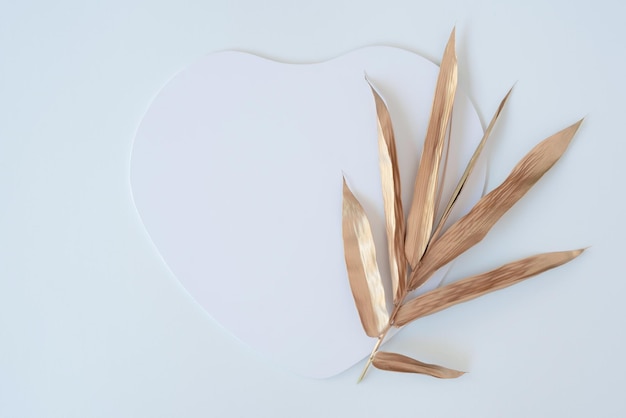 Heart shape cutout with golden color leaves. Love concept. Flat lay.