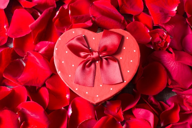 Heart shape gift box with petals  background