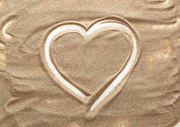 Photo heart shape made of sand. drawings in the sand.