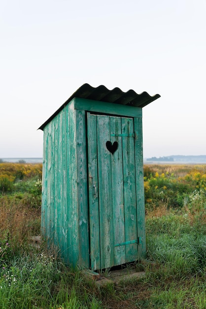 Heart shape on the old wooden toilet door green toilet in the field Outdoor recreation