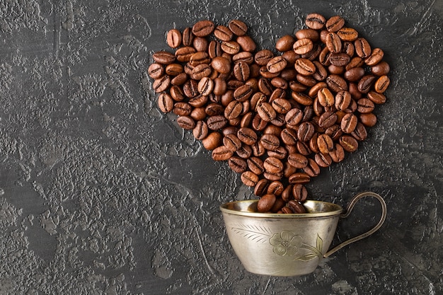 Heart shape of roasted coffee beans on dark background