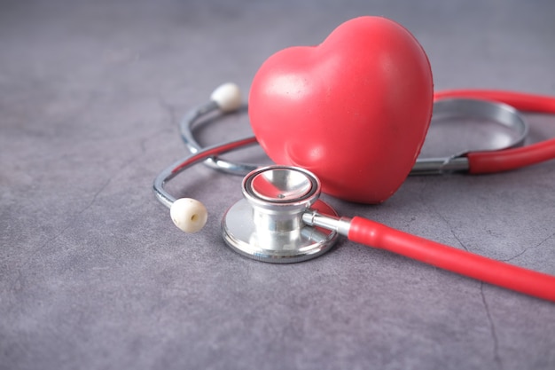 Heart shape symbol and stethoscope on white background